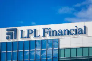 LPL Financial logo on a modern glass building under clear blue sky.