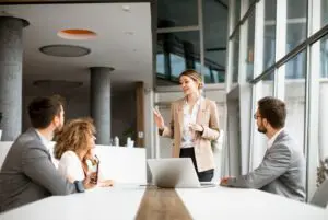 Professional woman leading a business meeting with attentive colleagues.