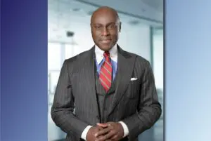 Professional man in a pinstripe suit and red tie standing confidently.