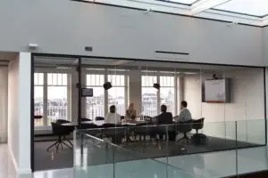 People having a meeting in a modern office with large windows.