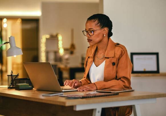 Woman working on laptop at desk.